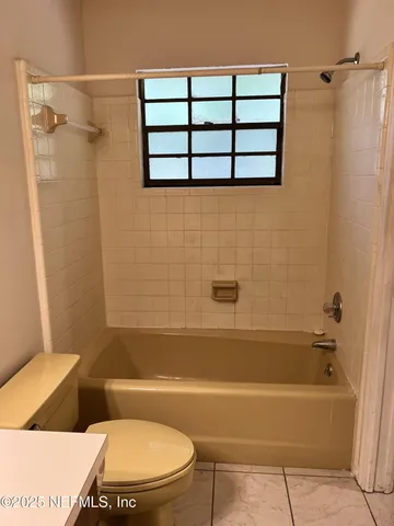 a bathroom with a toilet and a bath tub