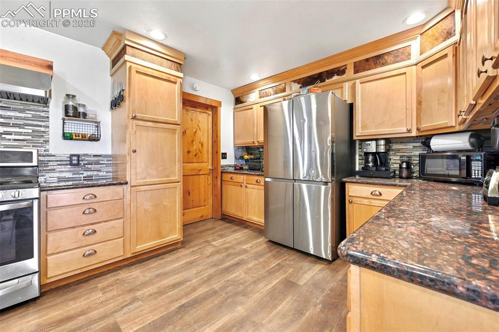 18560 Chelton Road Ramah, CO 80832 - Photo 4 of 34 a kitchen with granite countertop a refrigerator and a stove