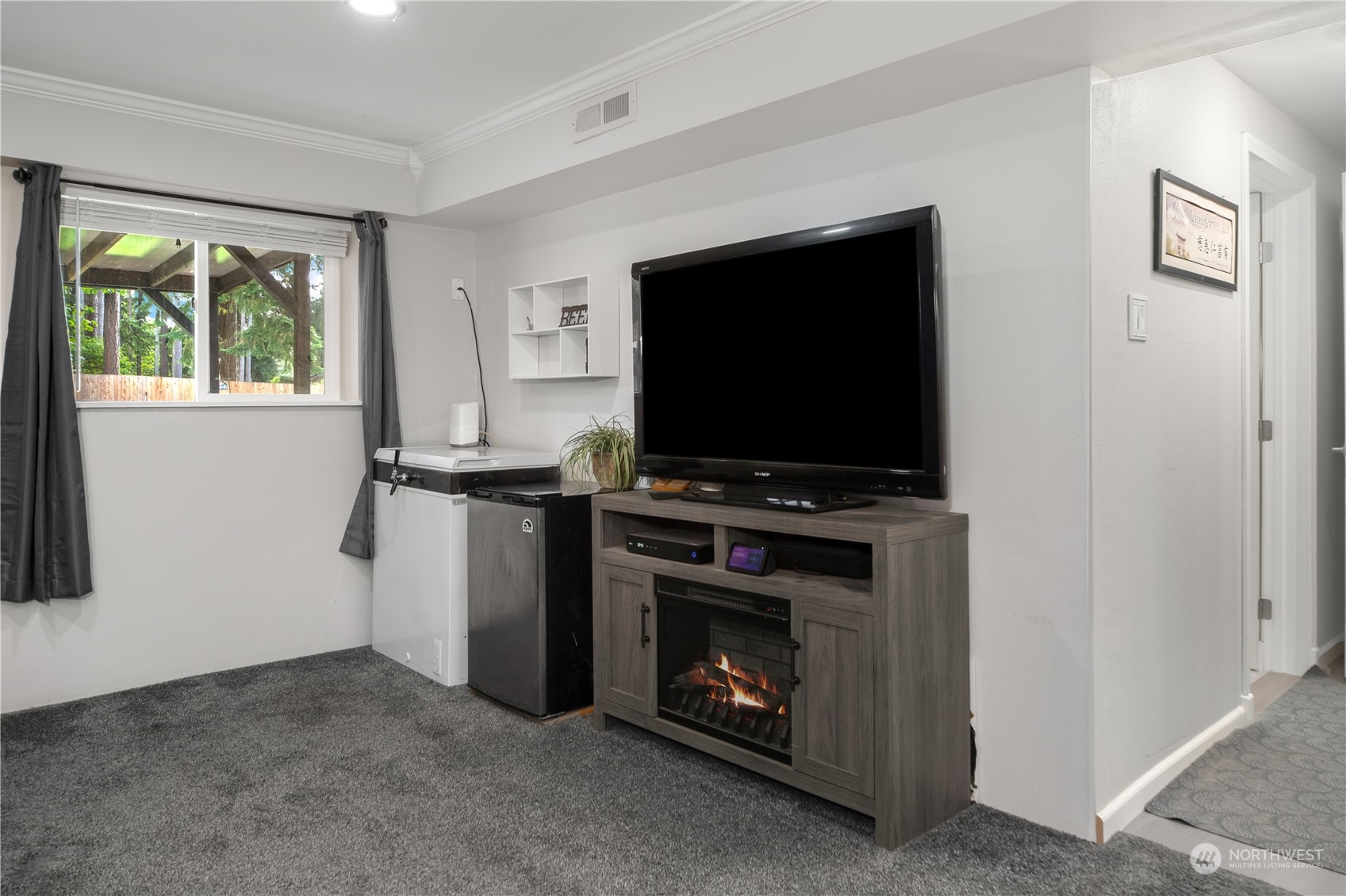 2401 Northeast John Carlson Road Bremerton, WA 98311 - Photo 18 of 36 a living room with a fireplace and a flat screen tv