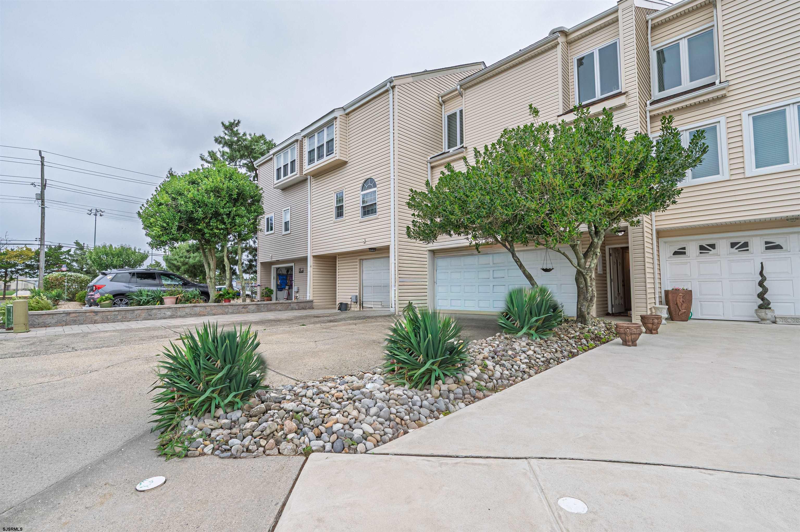 6 Marc Lane Brigantine, NJ 08203 - Photo 2 of 28 a front view of a house with a yard and potted plants