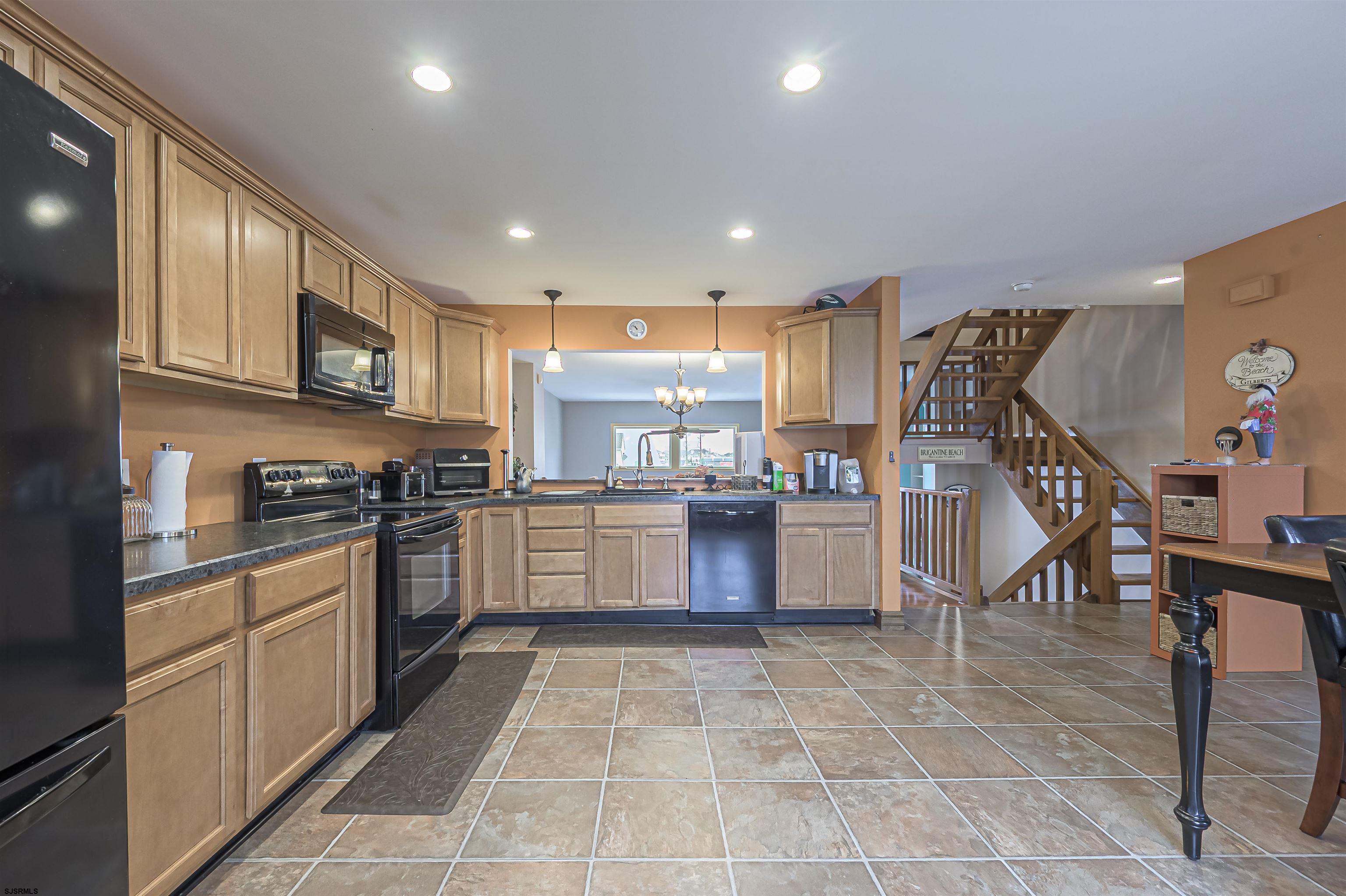 6 Marc Lane Brigantine, NJ 08203 - Photo 4 of 28 a kitchen with stainless steel appliances granite countertop a refrigerator and a stove top oven with wooden floor