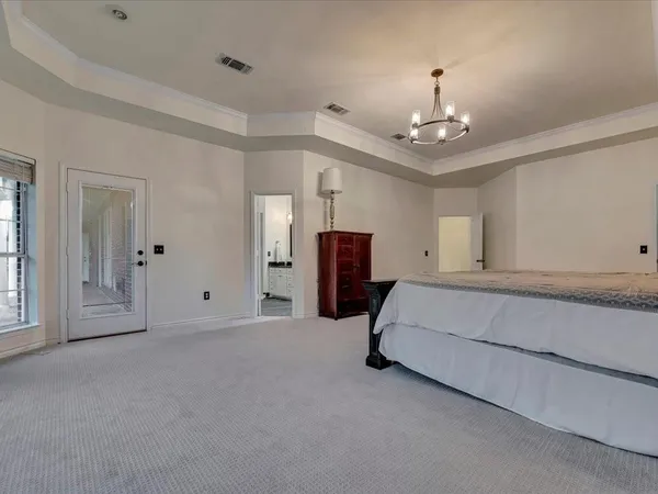 a spacious bedroom with furniture and window