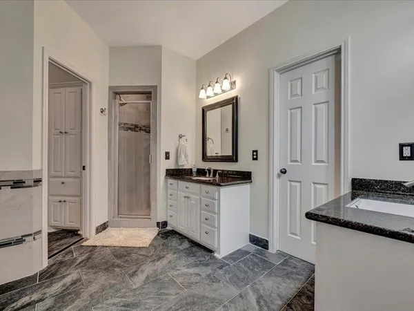 a spacious bathroom with a granite countertop sink and a mirror