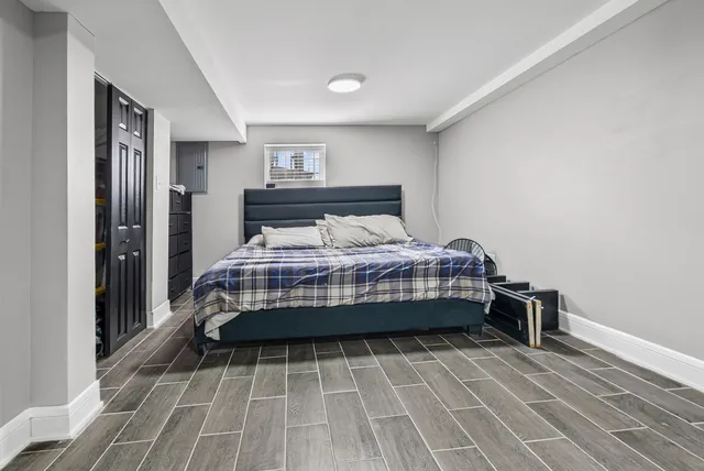 a bedroom with a bed and wooden floor