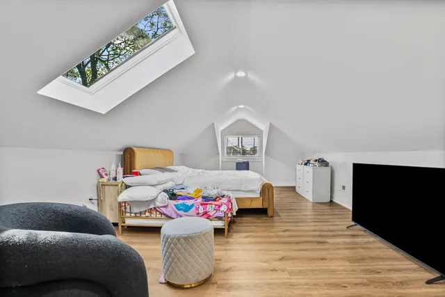 a bedroom with furniture and a flat screen tv