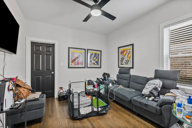 a living room with furniture a flat screen tv and a window