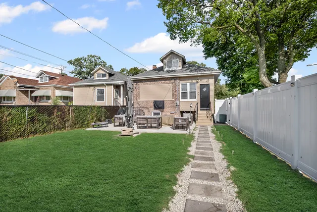 a front view of a house with garden and sitting area