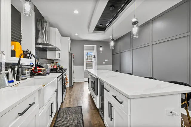 a kitchen that has a lot of cabinets and wooden floor