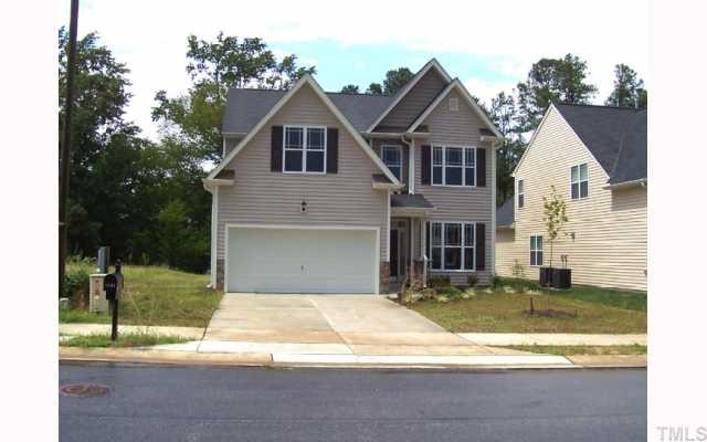 a view of a yard in front of a house with large windows