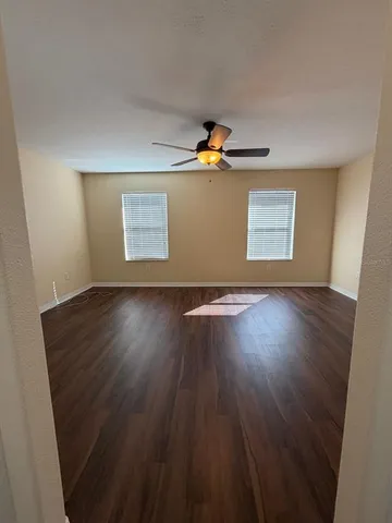 a view of a hallway with wooden floor and staircase