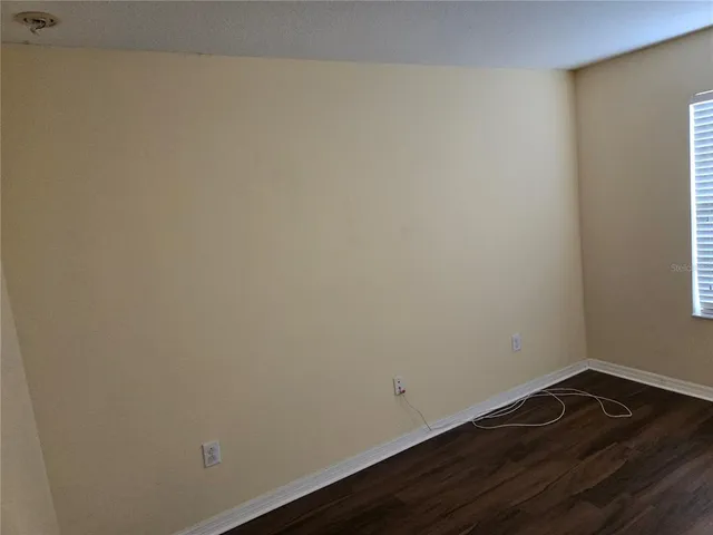 an empty room with wooden floor and mirror