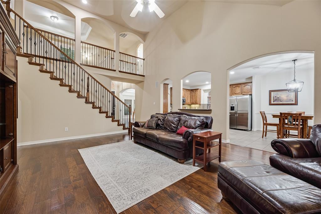 11920 Vienna Apple Road Fort Worth, TX 76244 - Photo 14 of 40 Expansive living room with hardwood floors, wood burning fireplace with gas starter, soaring vaulted ceilings and views of the upstairs game room and adjacent kitchen at 11920 Vienna Apple in Villages of Woodland Springs community in North Fort Worth