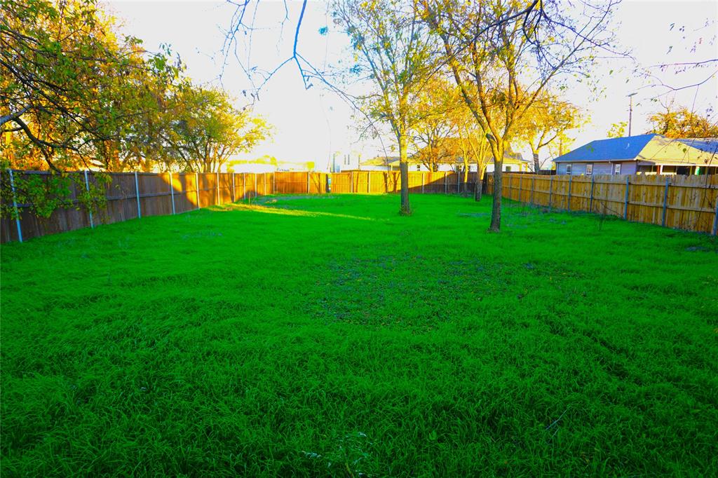 a view of yard with green space and house in the background