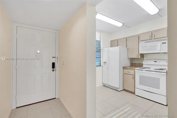 a kitchen with white cabinets and white appliances