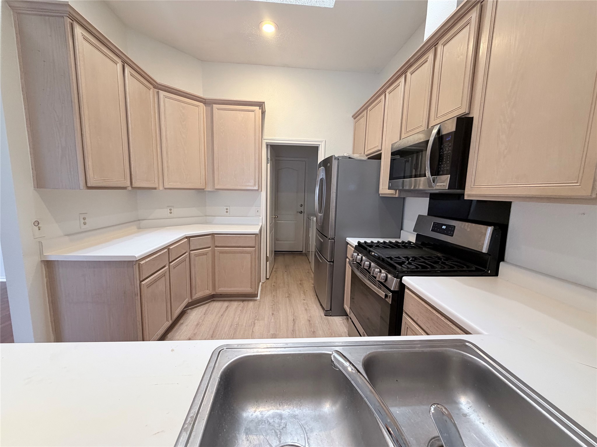 20809 Pacers Gait Lane Pflugerville, TX 78660 - Photo 21 of 23 Kitchen with stainless steel appliances, light wood finished floors, light countertops, and light wood finish cabinetry