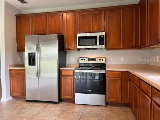 a kitchen with stainless steel appliances granite countertop a refrigerator stove and microwave
