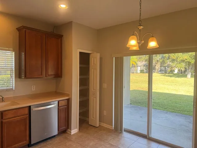 a kitchen that has a fridge and a view of living room