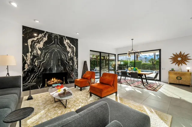 a living room with patio furniture and a floor to ceiling window