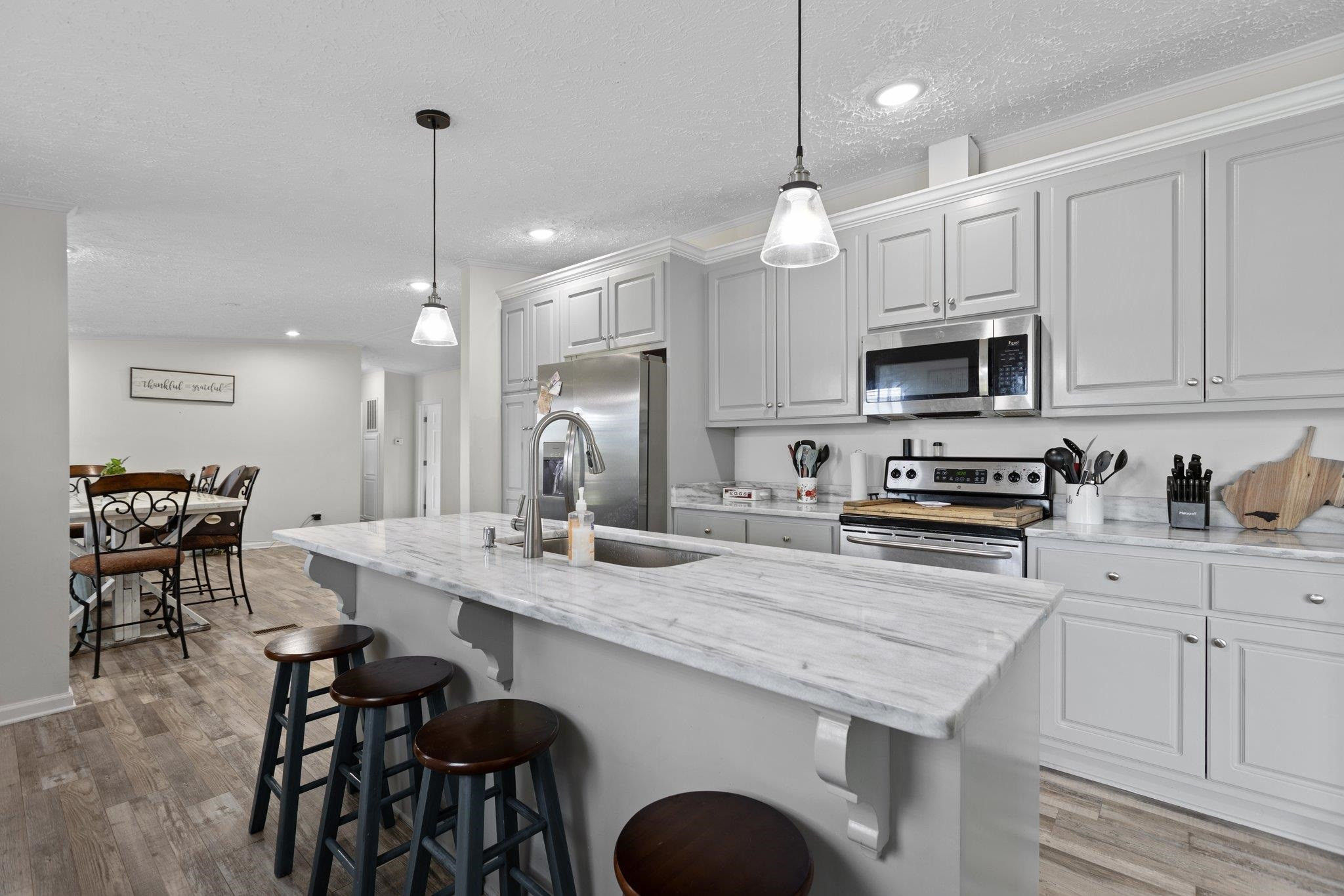 8148 Brooks Road Kenly, NC 27542 - Photo 10 of 38 a kitchen with kitchen island granite countertop a table chairs sink and cabinets