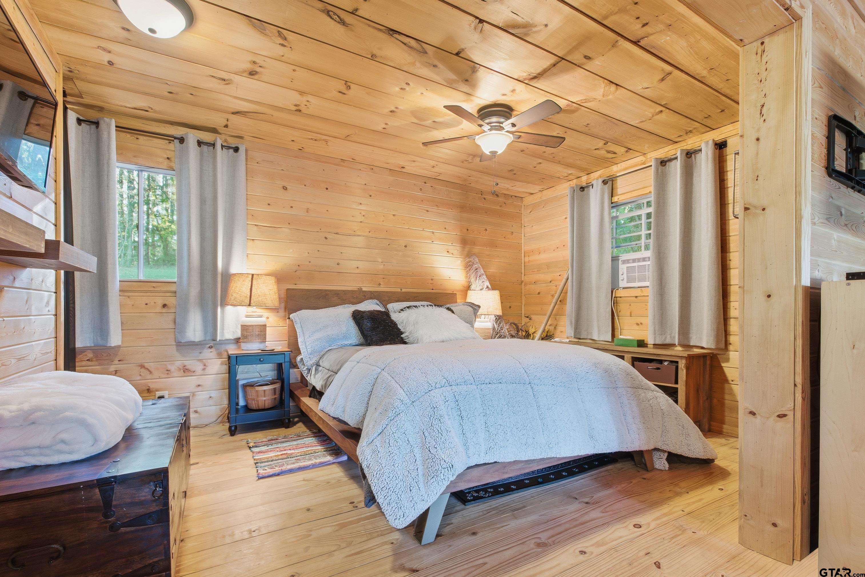 14525 Lake Road West Tyler, TX 75709 - Photo 16 of 30 a bedroom with a bed and wooden floor