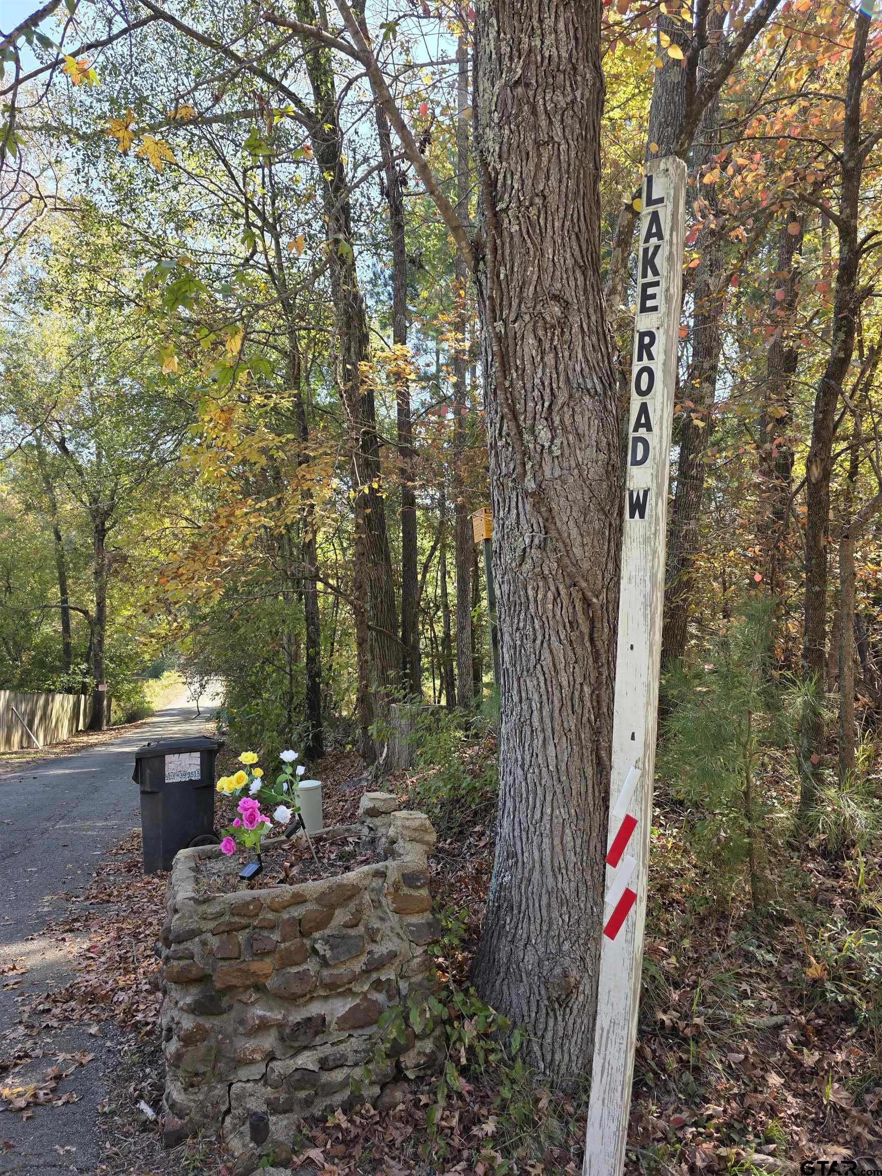 14525 Lake Road West Tyler, TX 75709 - Photo 21 of 30 a front view of a house with a tree and a red gate