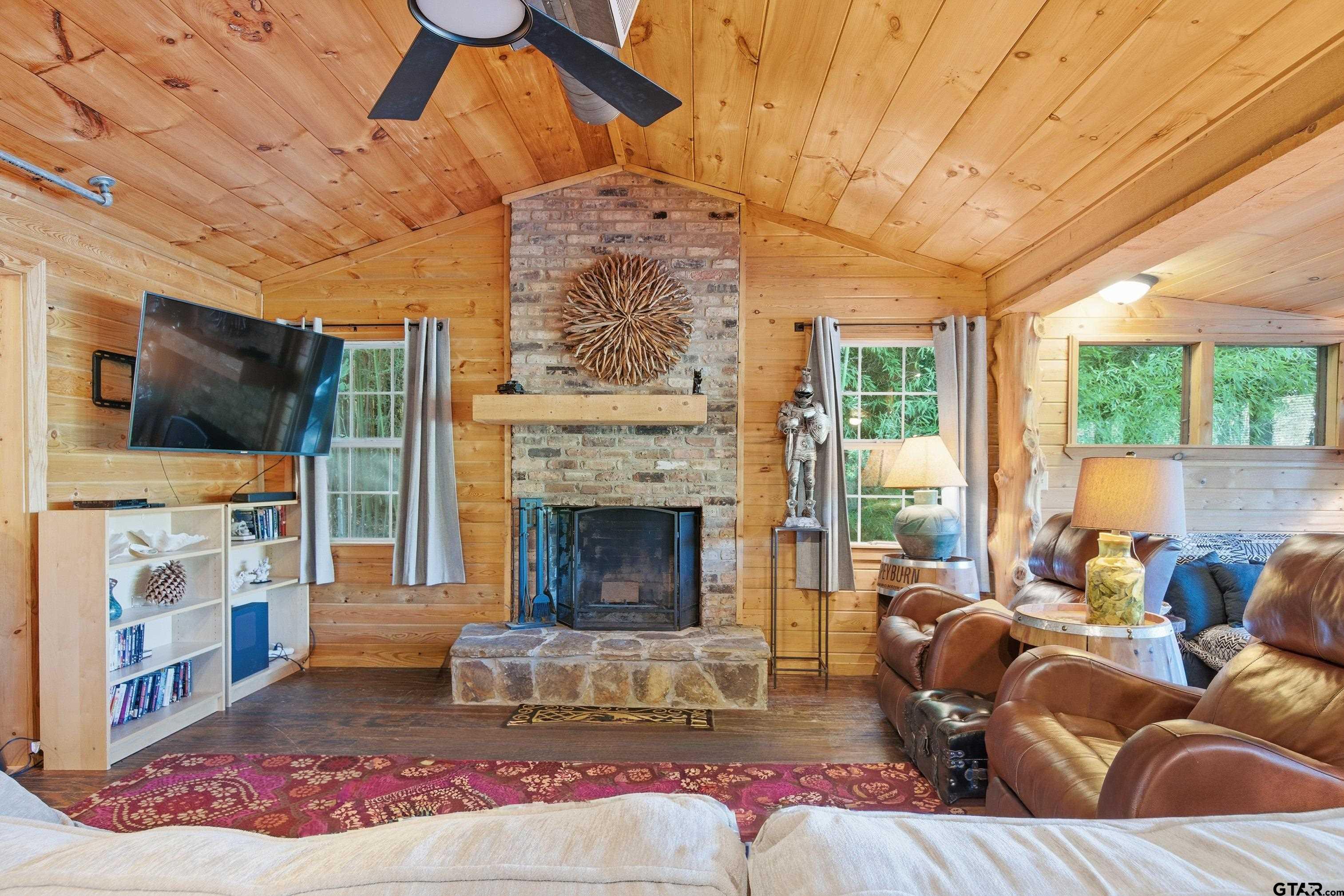 14525 Lake Road West Tyler, TX 75709 - Photo 22 of 30 a living room with furniture a flat screen tv and a fireplace