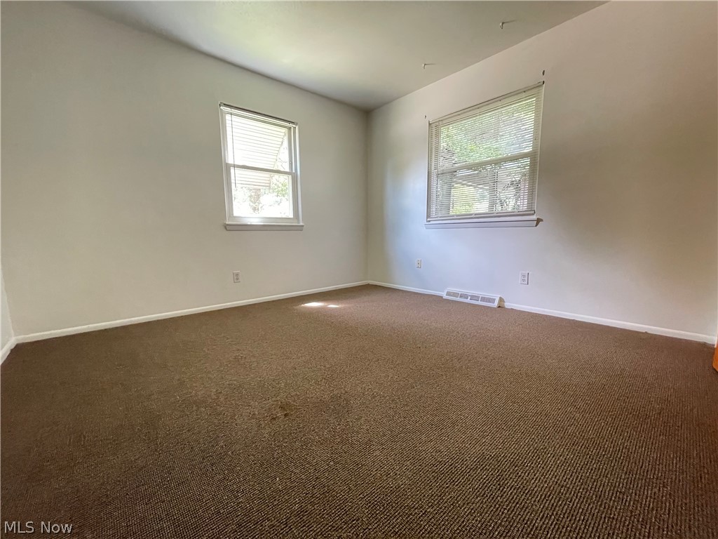 939 Nevin Street Akron, OH 44310 - Photo 10 of 23 Empty room with a wealth of natural light and dark colored carpet