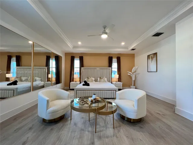 a view of a hallway with wooden floor and a living room