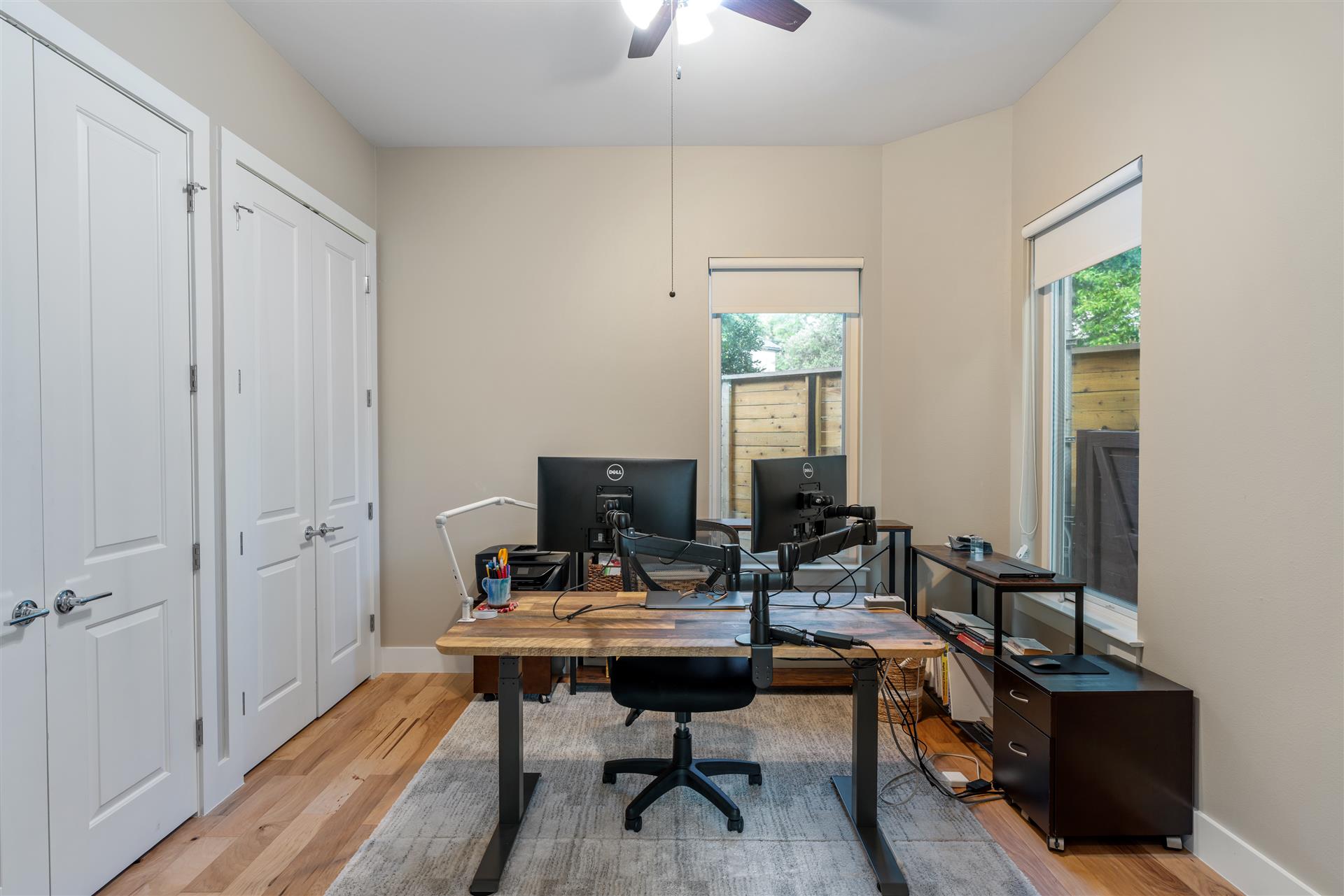 3806 Bull Creek Road, Unit B Austin, TX 78731 - Photo 14 of 37 Gleaming hardwood floors and abundant natural light define this versatile secondary bedroom, featuring two closets and a ceiling fan. The space also offers the flexibility to function beautifully as a home office or workspace.