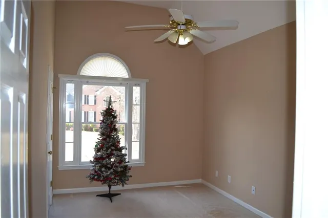 an empty room with a window and a chandelier