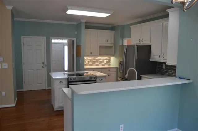 a kitchen with a refrigerator and a stove top oven