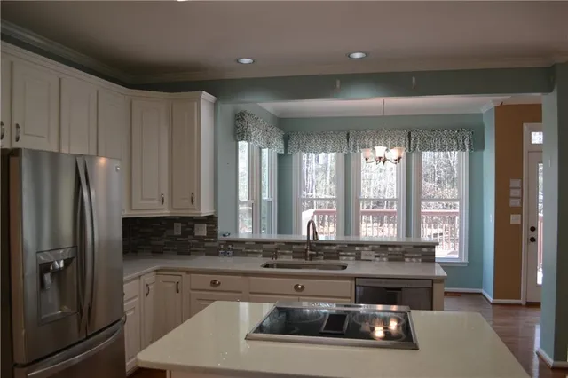 a kitchen with stainless steel appliances granite countertop a stove a sink and a refrigerator