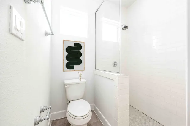 a bathroom with a toilet and a shower
