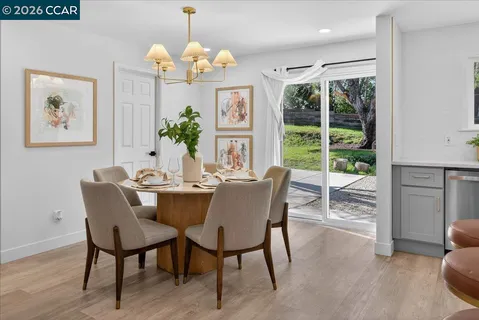 a dining room with furniture a large window and wooden floor