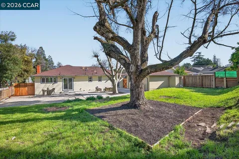 a view of a house with backyard and sitting area