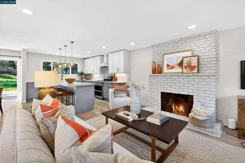 a living room with furniture fireplace and kitchen view