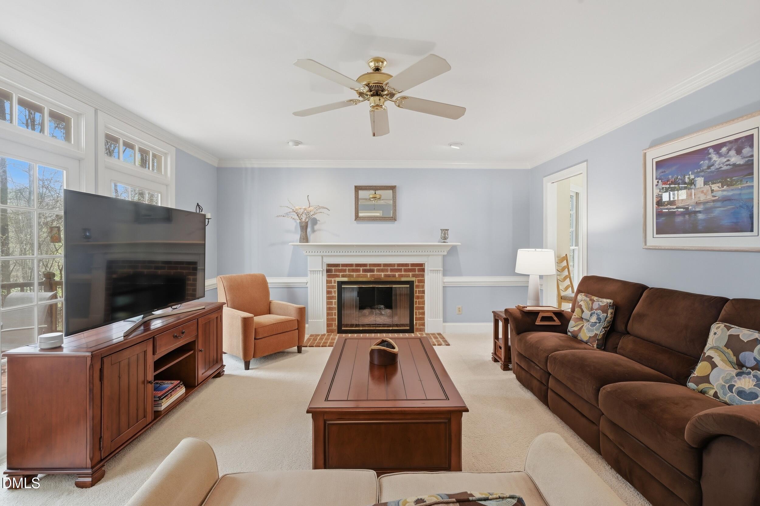 4001 Stemmons Court Raleigh, NC 27613 - Photo 15 of 45 a living room with furniture a flat screen tv and a fireplace