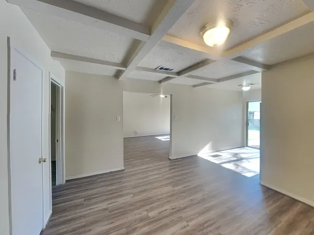 a view of empty room with wooden floor