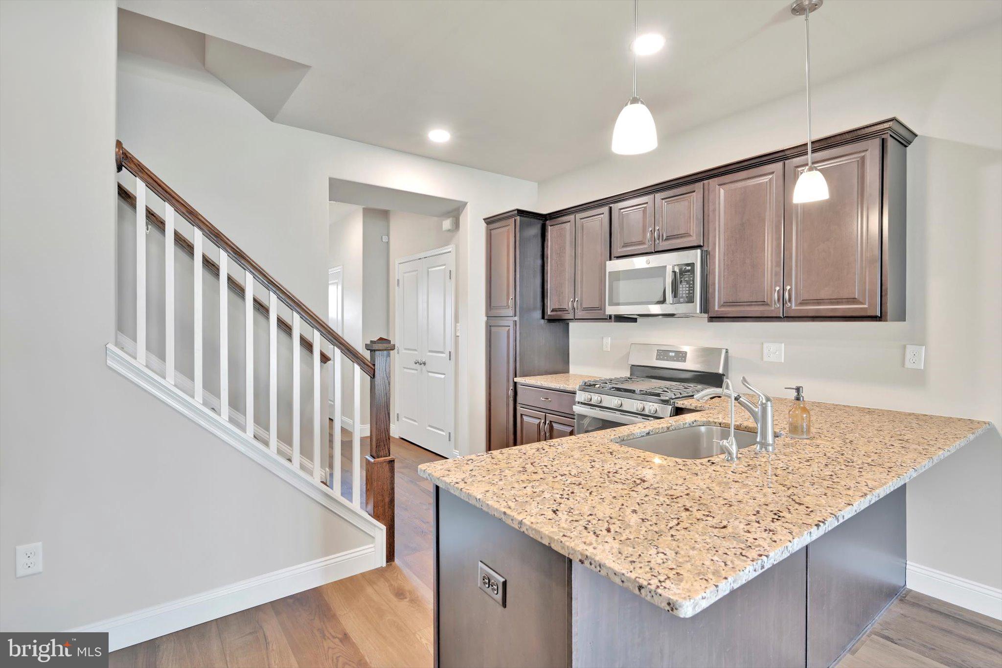 10 Hubbardton Court Sinking Spring, PA 19608 - Photo 6 of 25 a kitchen with stainless steel appliances granite countertop a sink refrigerator and microwave