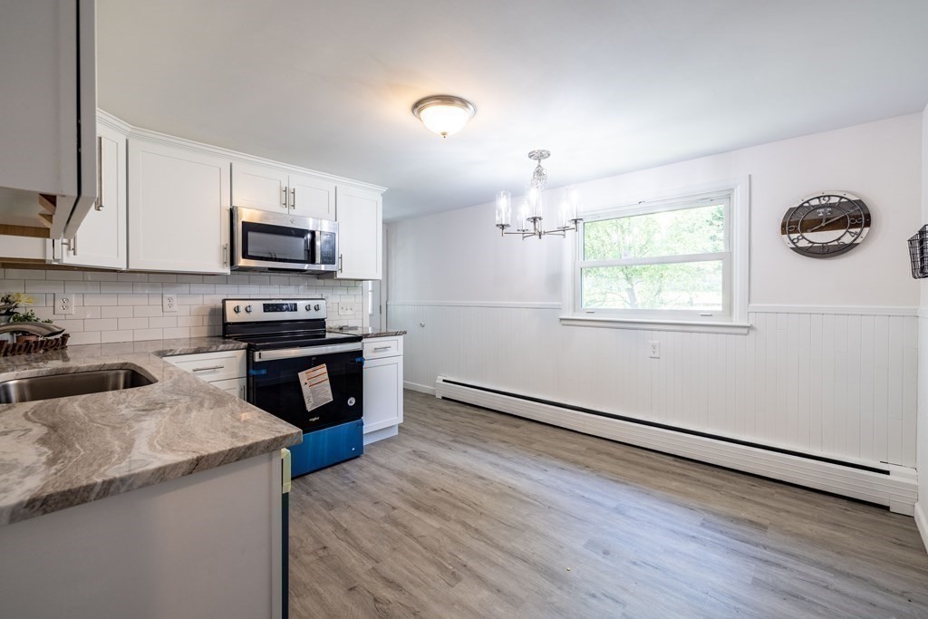 10 Sibley Street Three Rivers, MA 01080 - Photo 8 of 18 a kitchen with granite countertop a stove and a wooden floor