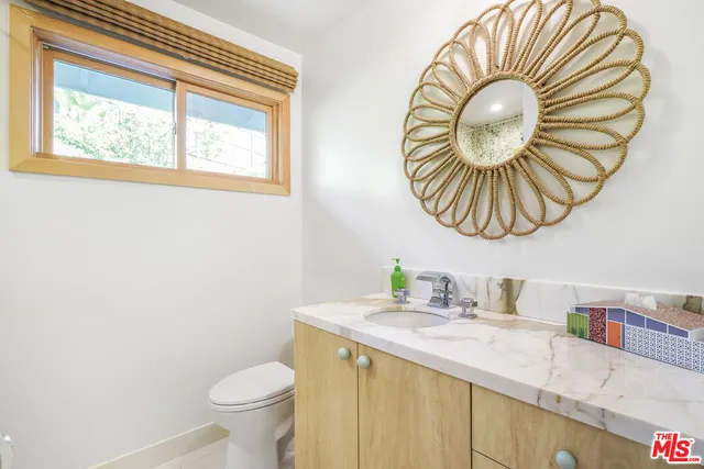 a bathroom with a sink a toilet and a mirror