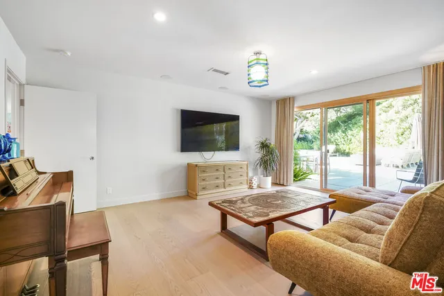 a living room with furniture a flat screen tv and a large window
