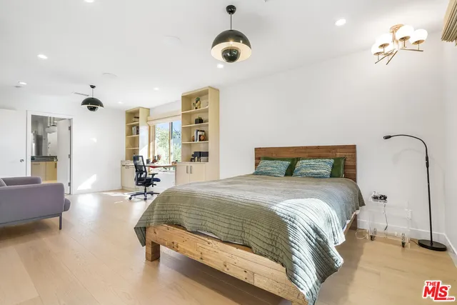 a bedroom with bed and a chandelier
