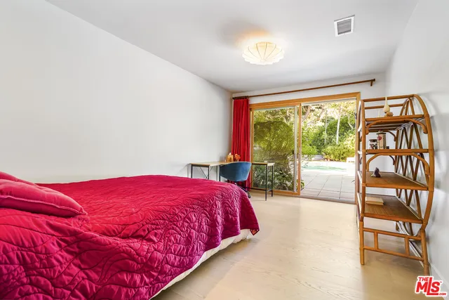 a bedroom with a bed and a large window