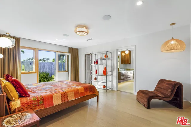 a bedroom with furniture and a large window