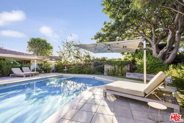 a view of backyard with swimming pool and outdoor seating