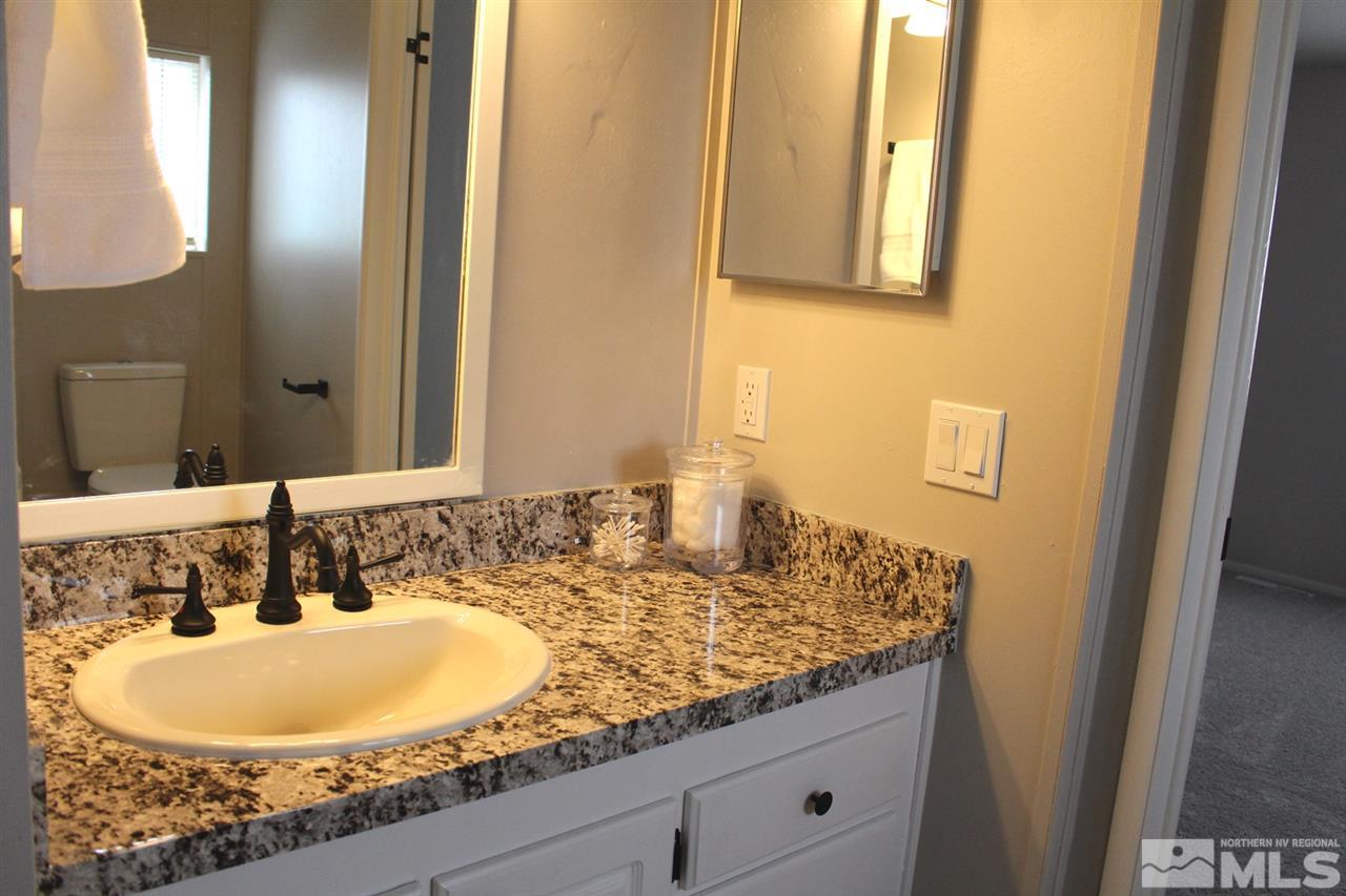 5189 Coggins Road Reno, NV 89506 - Photo 16 of 33 a bathroom with a granite countertop sink and a mirror