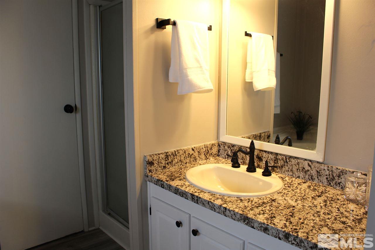 5189 Coggins Road Reno, NV 89506 - Photo 18 of 33 a bathroom with a granite countertop sink and a mirror