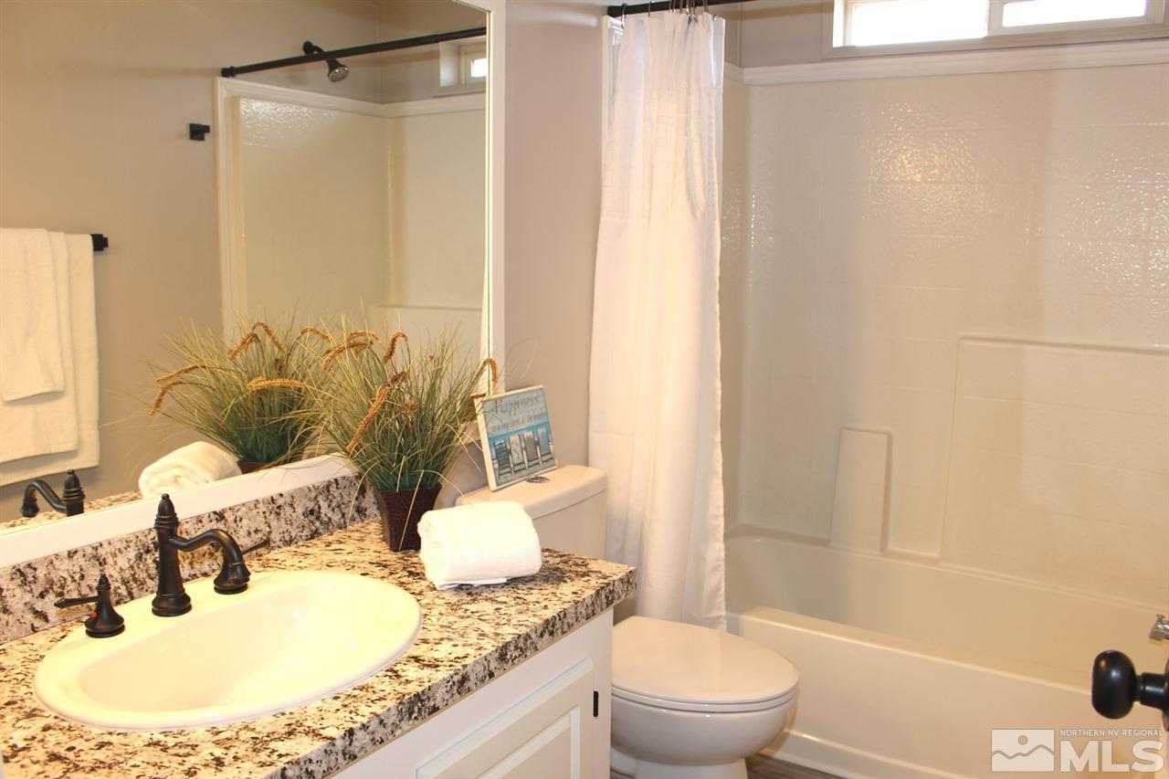 5189 Coggins Road Reno, NV 89506 - Photo 19 of 33 a bathroom with a granite countertop sink toilet and shower