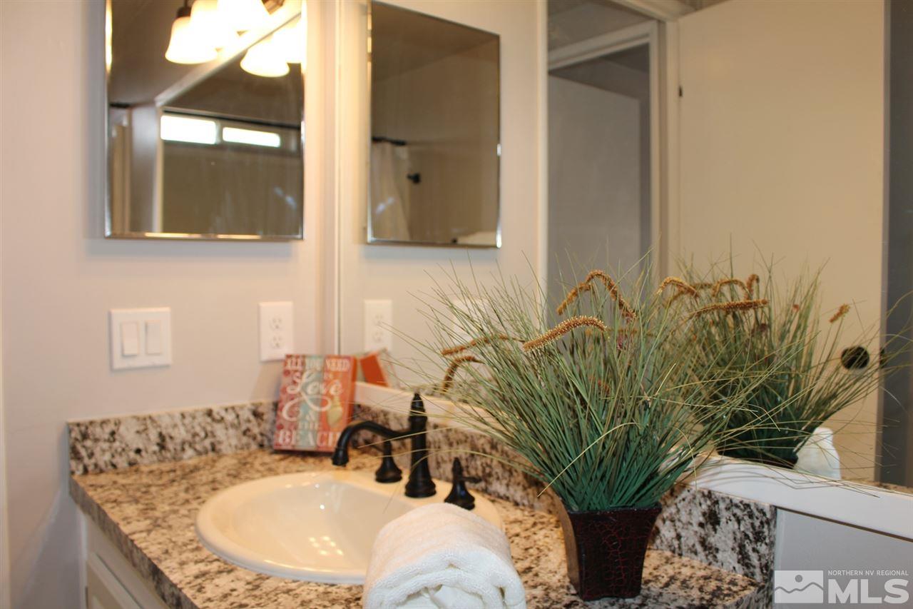 5189 Coggins Road Reno, NV 89506 - Photo 20 of 33 a bathroom with a granite countertop a sink a mirror and a potted plant